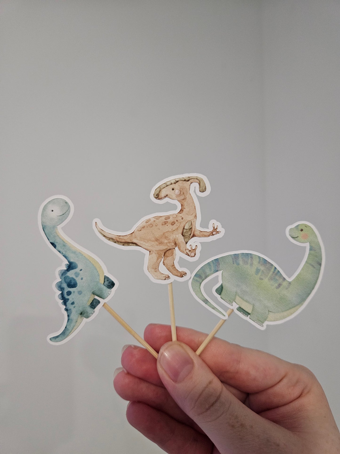 3 dinosaur cupcake toppers on white background