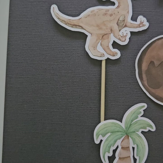 video of dino cupcake toppers on black background